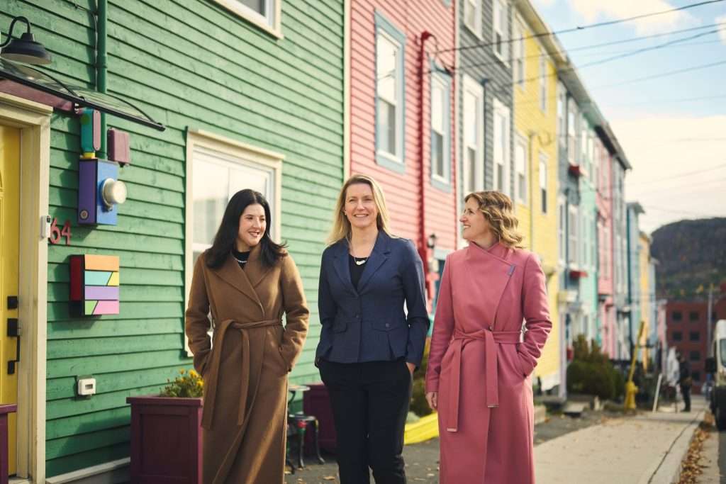 lawyers walking in front of colorful houses